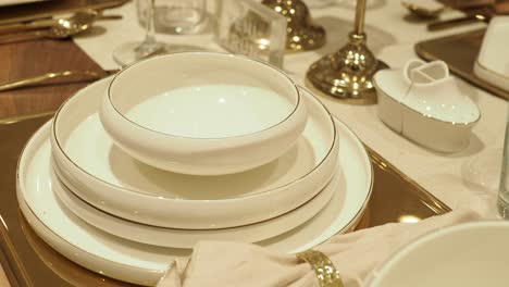 elegante decoración de la mesa con platos blancos y acentos dorados