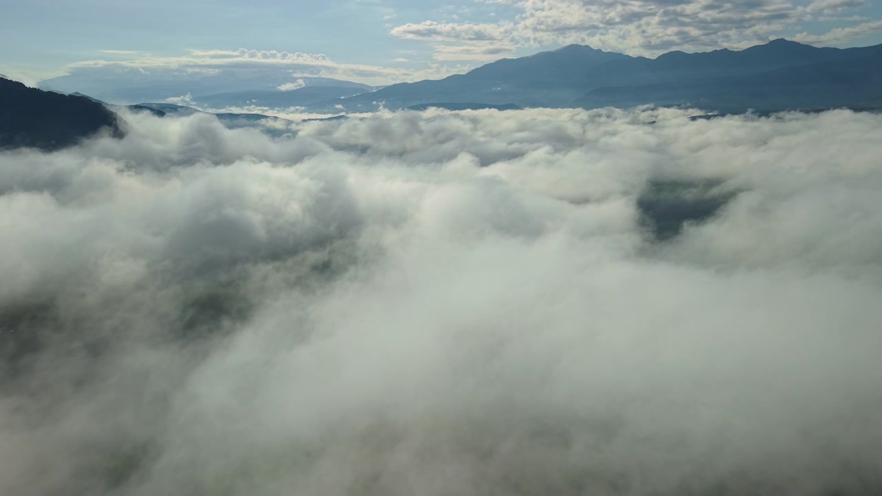 Drone View of Morning Fog Rolling Over a Mountain Valley