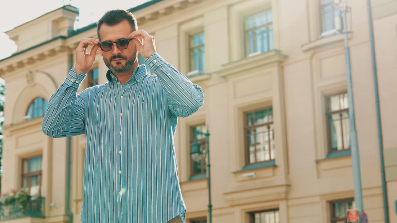 Uomo con camicia a righe in una strada cittadina