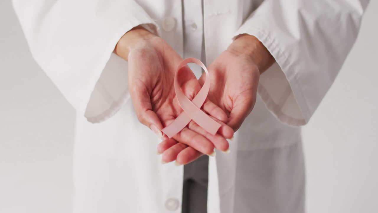 Video di dottoressa di etnia mista che tiene un nastro rosa per il cancro