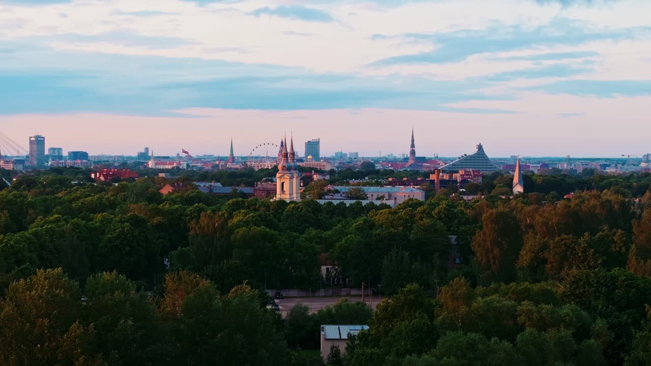 Early morning drone shot from Pārdaugava reveals Riga skyline in warm sunrise