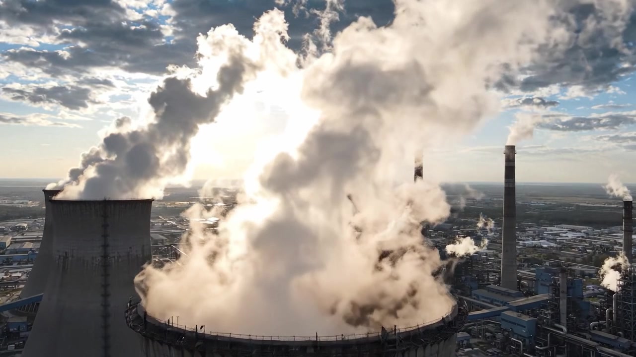 Vista Aerea di una Centrale Elettrica Industriale Che Emette Vapore e Fumo Sotto un Cielo Drammatico, Mettendo in Mostra l'Infrastruttura e i Processi di Generazione di Energia