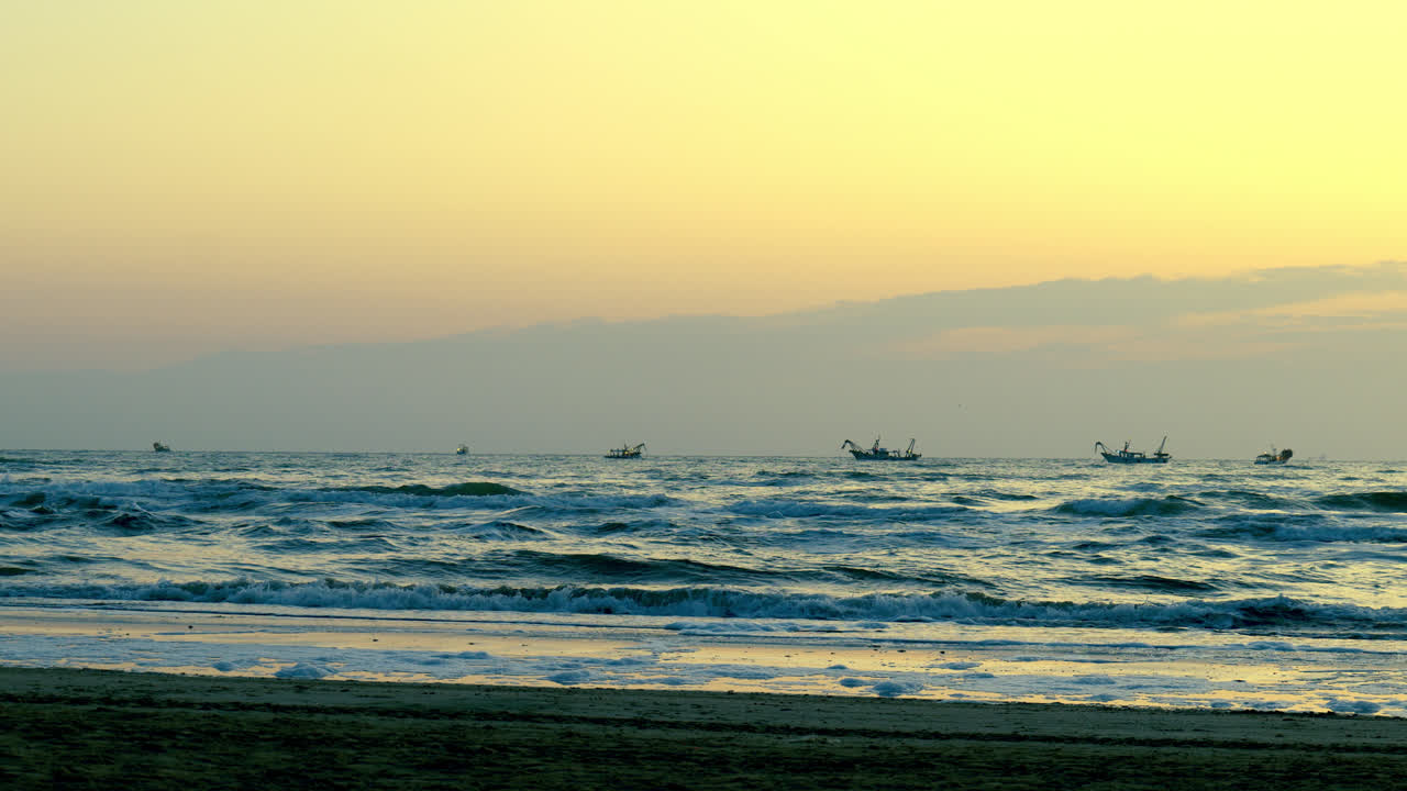 시 보트 는 해가 뜨면 멀리서 평화로운 해변 근처 에 있는 평온 한 바다 파도 위 에 항해 한다