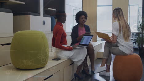 animation of connected icons, numbers, letters, symbols on diverse coworkers discussing reports