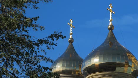 view of orthodox st nicholas naval cathedral golden domes and crosses on blue sky in sunny autumn day at karosta, liepaja, medium shot