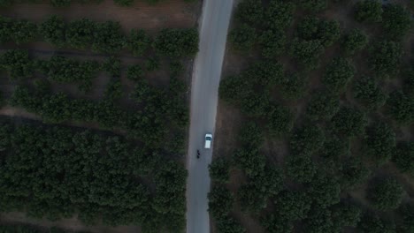 car and motorcycle across the countryside road near chania in crete, greece. aerial tracking shot