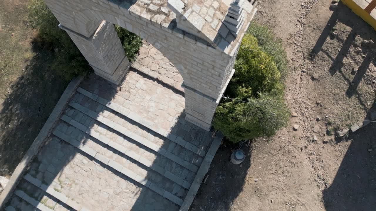 tiro aéreo de arriba hacia abajo sobre ruinas y arco de piedra puerta de entrada de la iglesia española