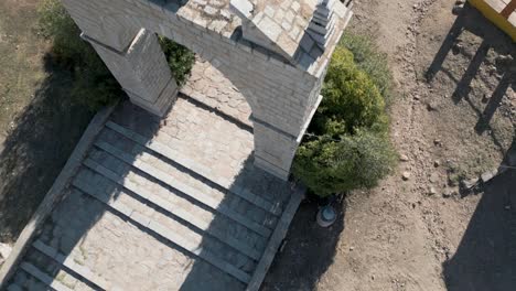 tiro aéreo de arriba hacia abajo sobre ruinas y arco de piedra puerta de entrada de la iglesia española