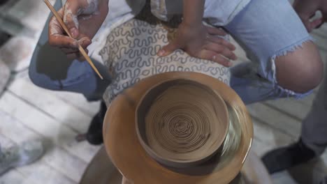 persona que da forma a la arcilla en la rueda de la cerámica