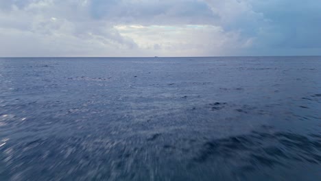 Rolling-ocean-waves-with-mysterious-clouds-on-hazey-horizon,-sea-water-aerial-texture