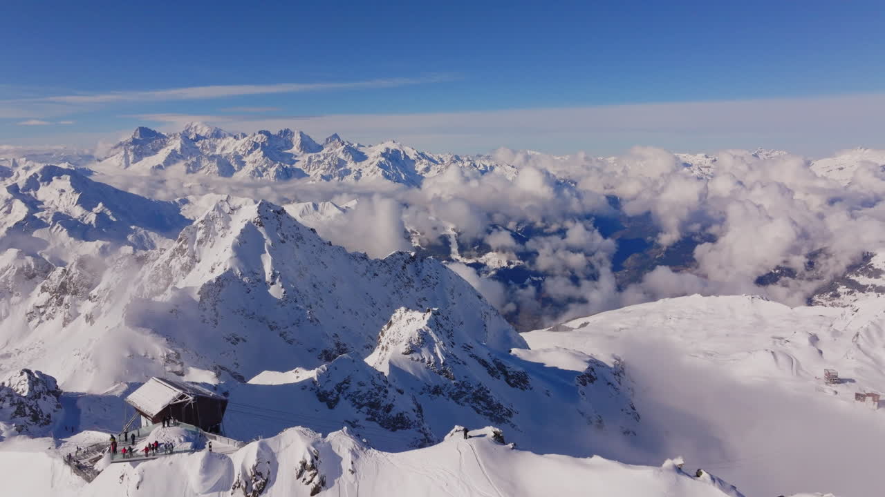 Aerial footage of the iconic freeride paradise of Verbier on a stunning bluebird day. Snow-covered peaks, wide open faces, and legendary off-piste terrain under clear alpine skies