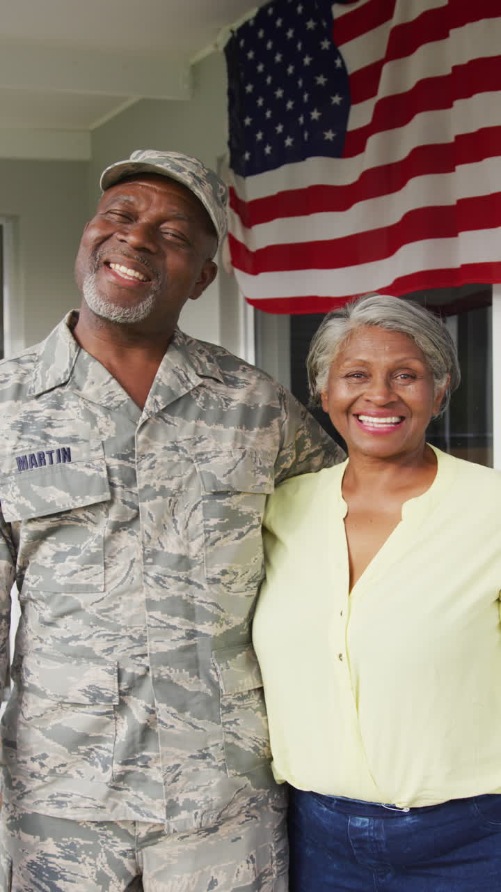 retrato vertical de video de un feliz soldado afroamericano y su esposa con bandera estadounidense
