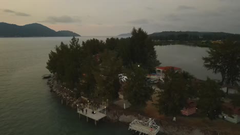 drone view of road, cafe and pine trees along marina island, malaysia