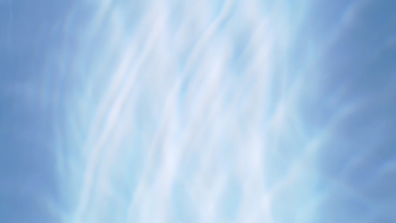 Top view slow motion of drop falling into the water surface and diverging circles on white background