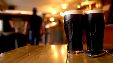 two pints of stout in a pub