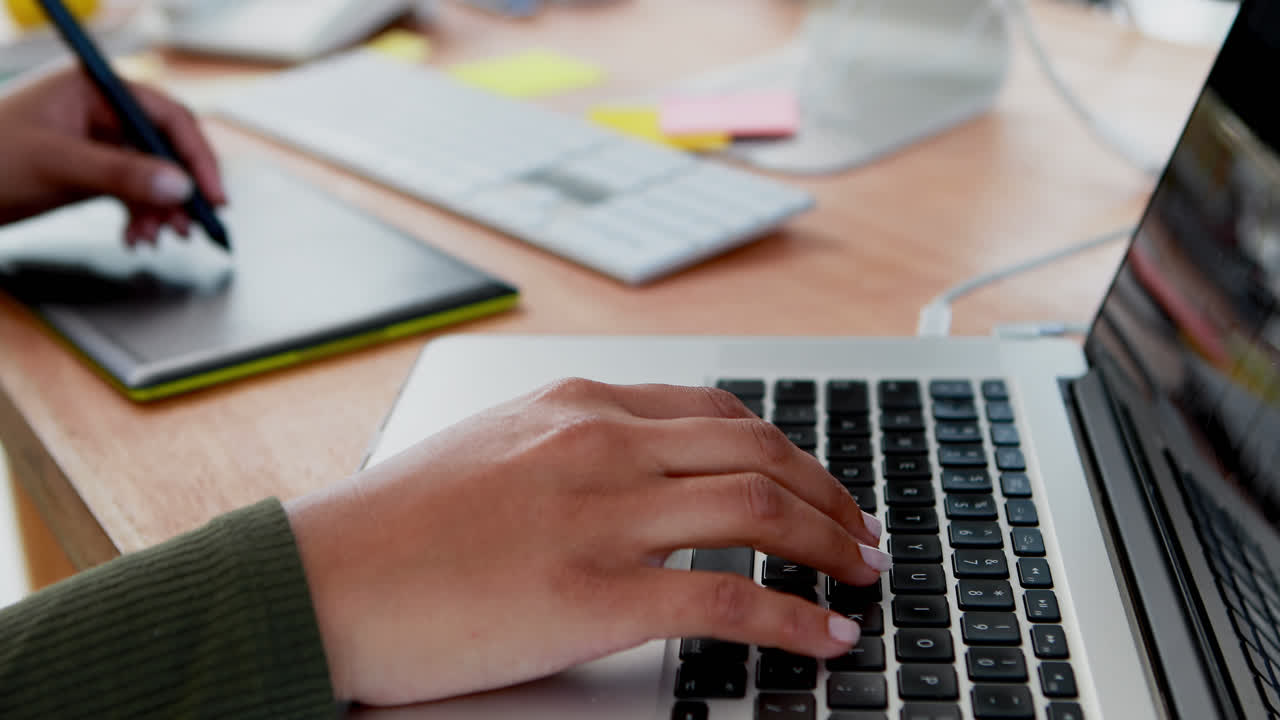 Female graphic designer using graphic tablet and laptop 4k