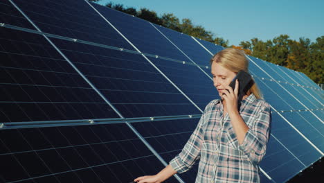 woman with smartphone goes aquarius solar panels at home solar power plant