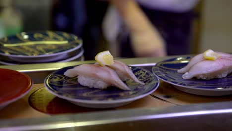 4k, sushi moviendo la cinta transportadora en el restaurante japonés. kaitenzushi tradicional