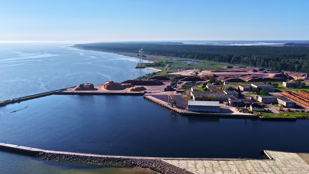 Fotografía con dron de una terminal portuaria con almacenamiento de madera junto al mar