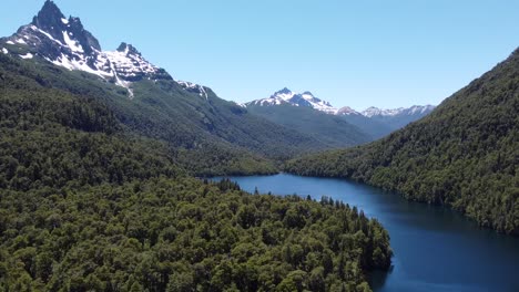 another shot of this amazing lake surrounded by green forest and snow mountains. captured in patagonia argentina