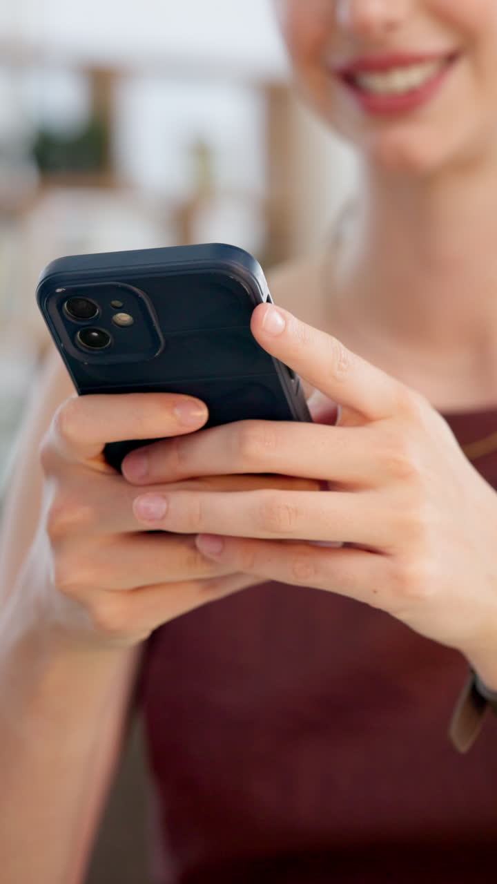 Primo piano delle mani di una donna che usa lo smartphone e sorride