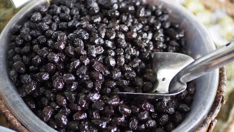 close-up of a bowl of black olives at a market