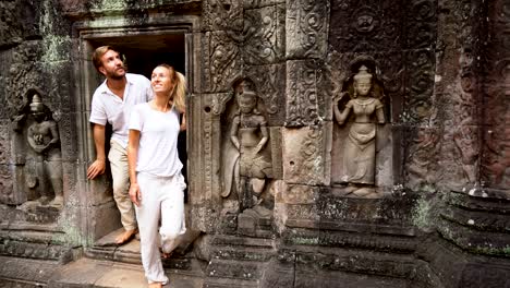 young couple discovering the treasures of cambodia, angkor wat exploring ancient temples