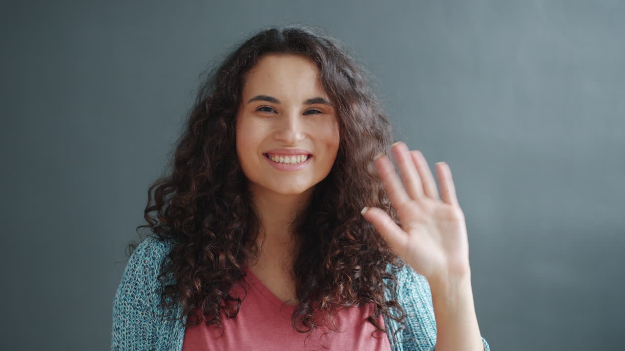 una mujer saludando.
