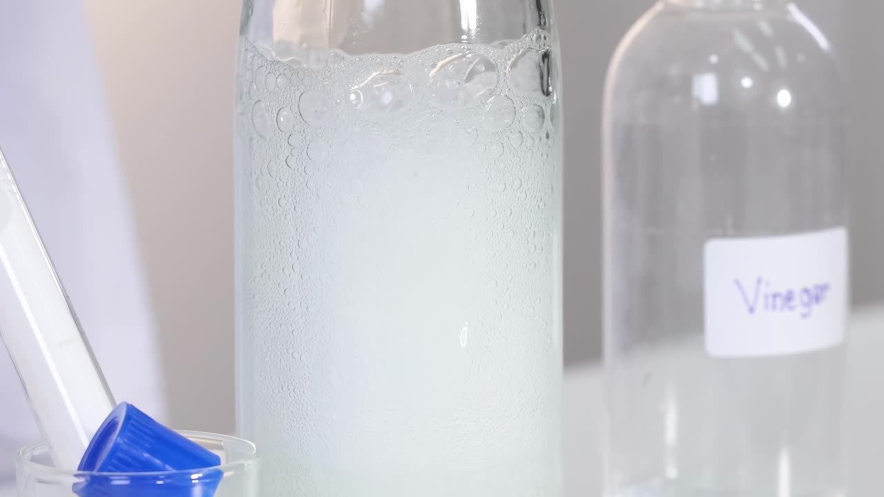 Observe the fizzing reaction in a glass bottle with a vinegar container nearby.