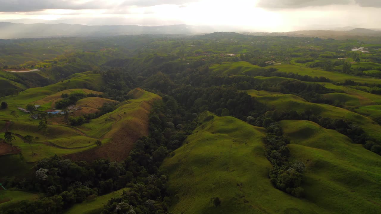 녹색 콜롬비아 초원 언덕과 혼합 된 날씨와 먼 비 폭풍, 공중