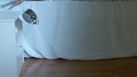 una mujer rubia bajando su despertador.