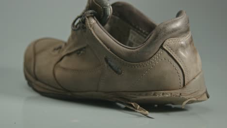 Dolly-out-of-worn-hiking-shoes-against-a-white-background