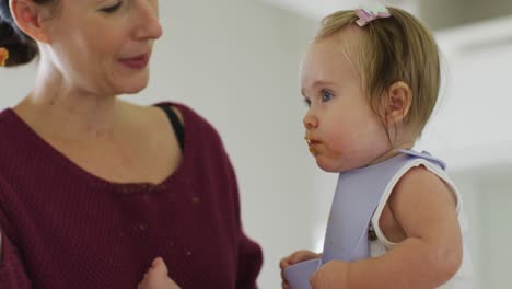 primer plano de una madre caucásica alimentando a su bebé en casa