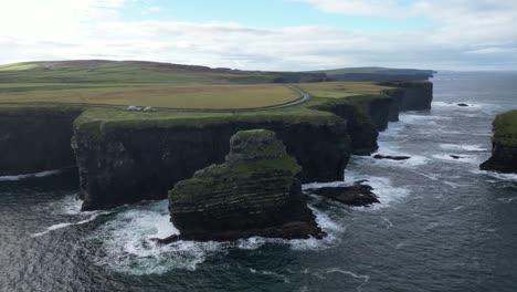 Luftaufnahme-Majestätischer-Klippen-Am-Meer-Mit-Tosenden-Wellen-Unter-Einem-Weiten-Himmel