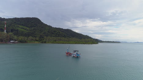 Pan-around-shot-of-a-sinking-fishing-boat-off-the-coast-of-an-idyllic-secluded-island-in-Thailand