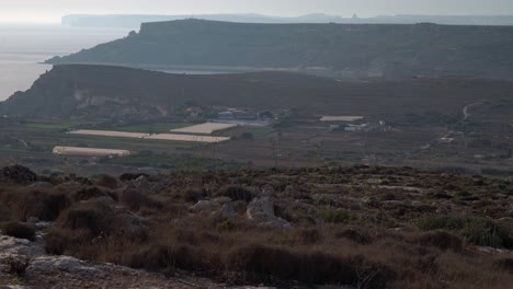 paisaje rocoso y tierras agrícolas en mellieha con el mar mediterráneo y la isla de gozo en el fondo en malta.
