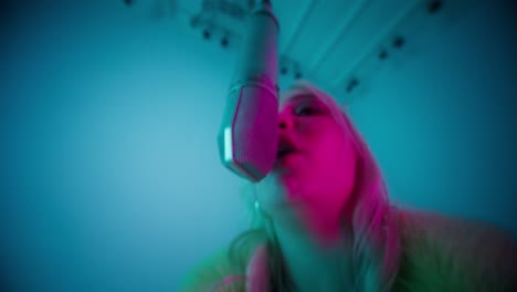 mujer cantando en un micrófono en un estudio