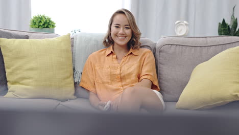 happy woman on couch watching tv for funny show