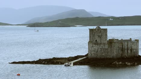 Kisimul-Castle-Mit-Blick-Auf-Castlebay-An-Einem-Nebligen-Tag-Mit-Einer-Vorbeisegelnden-Yacht