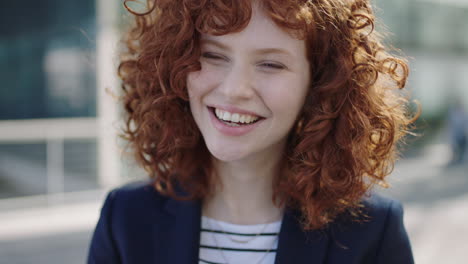 retrato de una joven de cabello rojo mujer de negocios riendo feliz interno campus