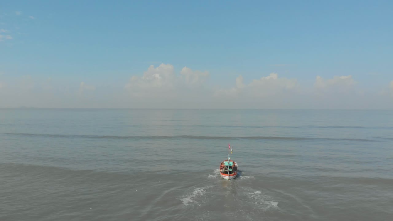 падение следит за дроном, который снимает маленькую красочную индийскую рыбацкую лодку, выходящую в море.