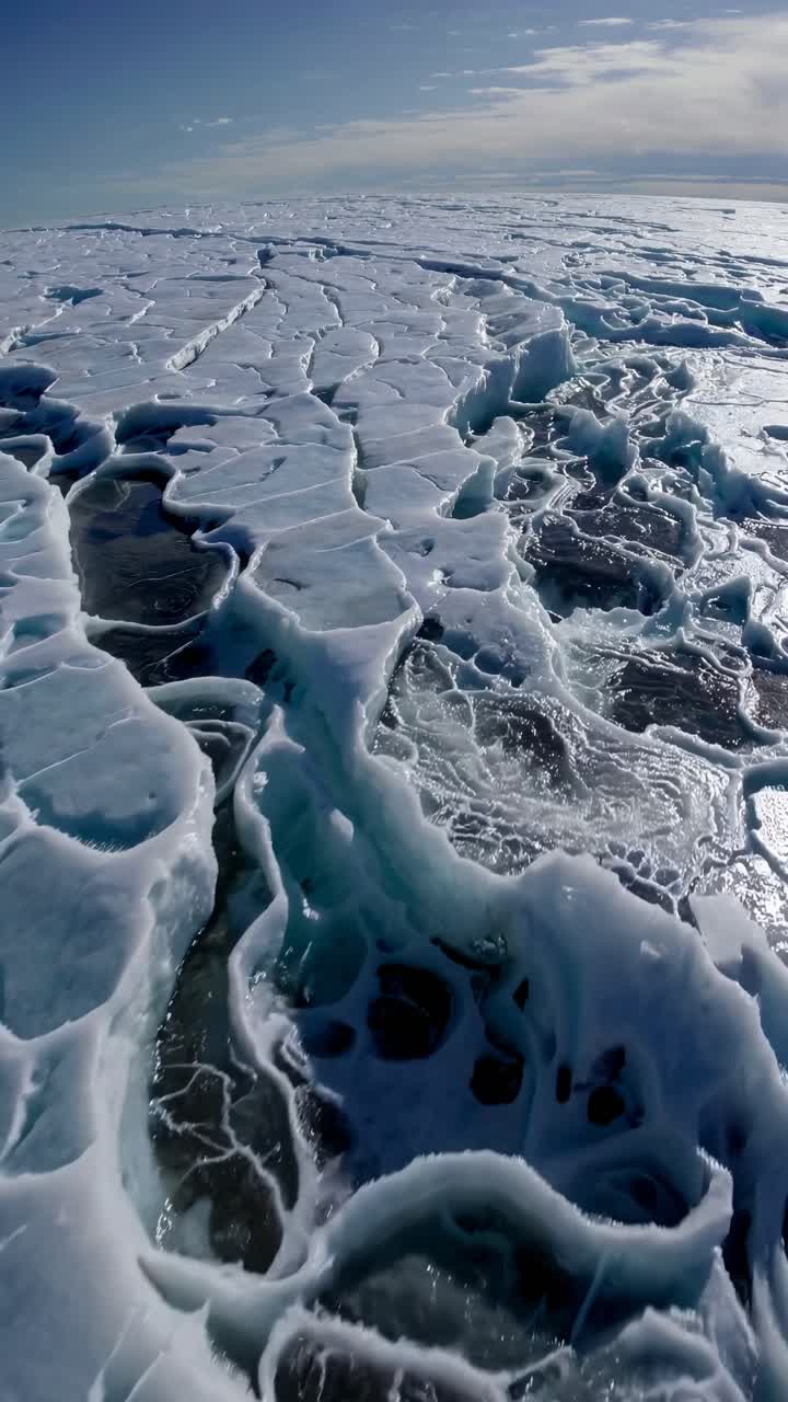Aerial view of cracked ice patterns on a frozen landscape, showcasing nature's abstract art