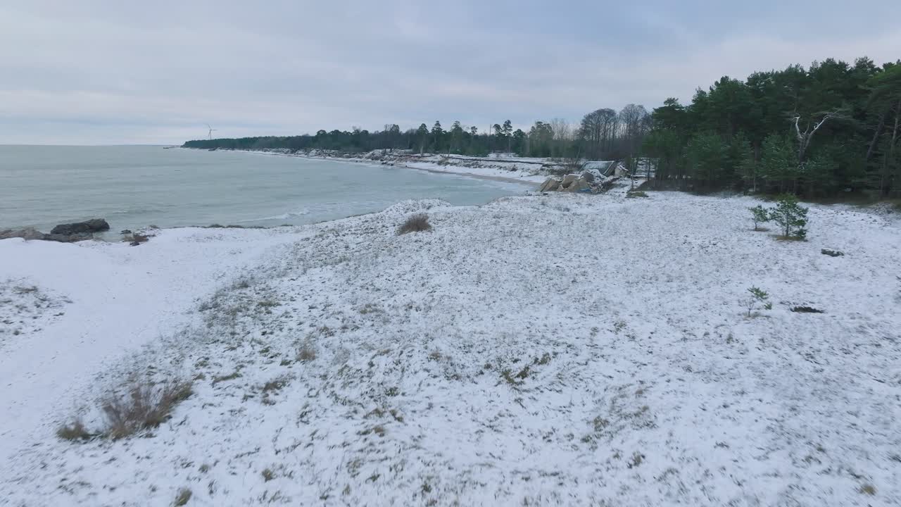 발트해 해변의 카로스타 북부 요새에 있는 버려진 해변 요새 건물의 공중 설정, 흐린 겨울날, 앞으로 낮게 움직이는 넓은 드론 샷