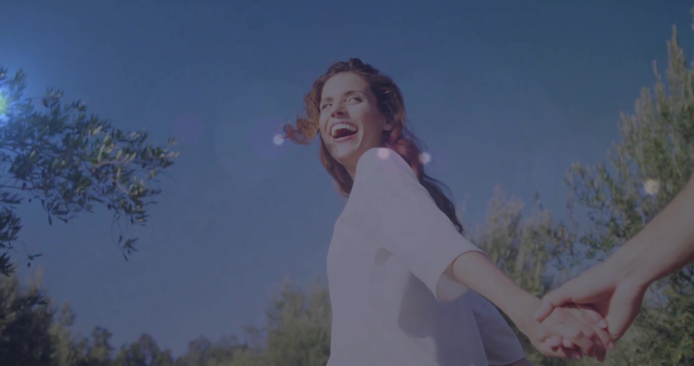 Woman leading him with hand tug, guiding along forest path with animated flare for travel ad