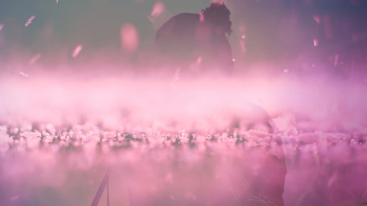 male silhouette adjusting microphone stand in music production set, with animated pink haze effect