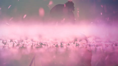 male silhouette adjusting microphone stand in music production set, with animated pink haze effect