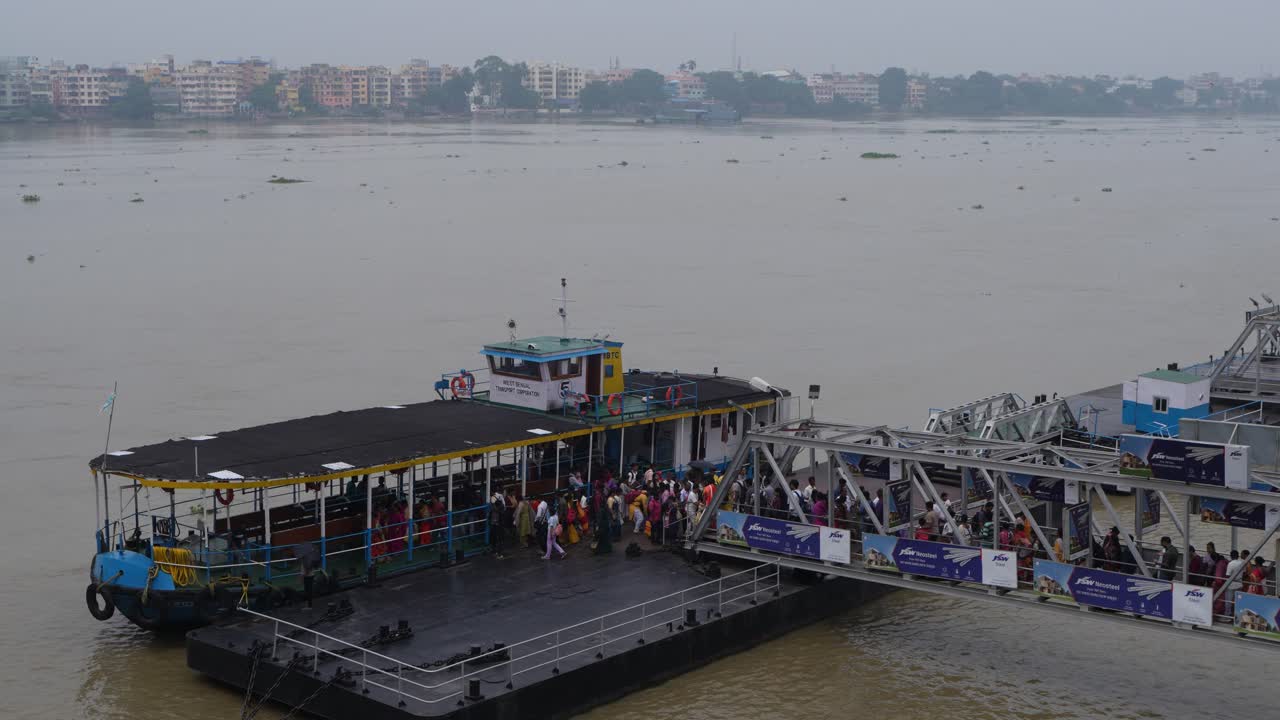 People are boarding the ship from the wharf.