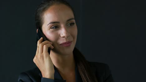 Businesswoman-speaking-on-phone-and-looking-up
