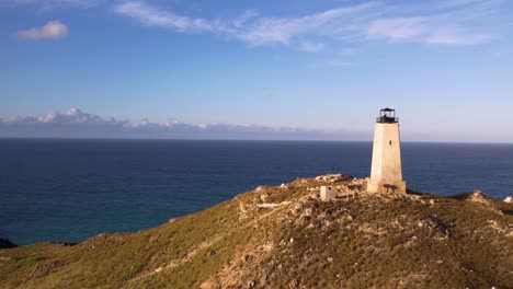 Alter-Leuchtturm-An-Einer-Zerklüfteten-Küste-Mit-Blick-Auf-Das-Meer,-Klarer-Himmel