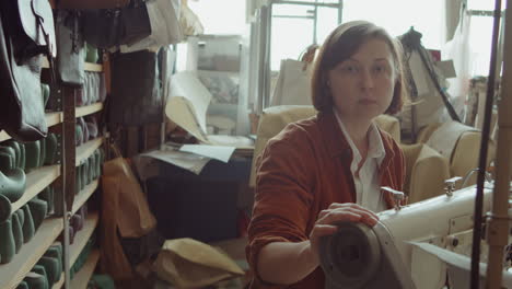 portrait of woman with sewing machine in shoemaker workshop